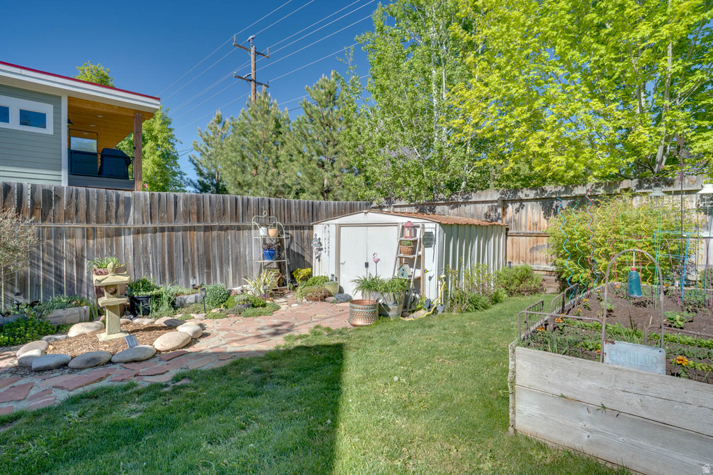 Expansive backyard featuring a manicured lawn, a garden shed, and a raised garden bed