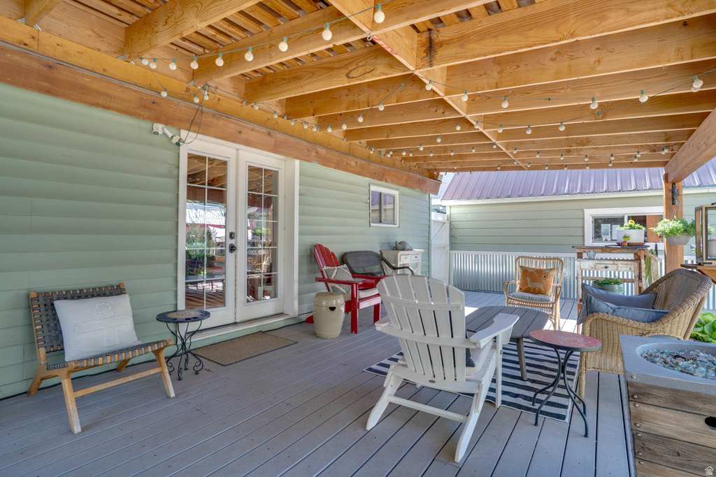 Covered outdoor patio featuring a wood-finish ceiling, string lighting, and direct access through double glass-paneled doors