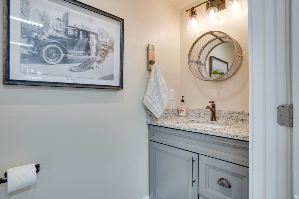 Vanity with a speckled countertop, undermount sink, and bronze-finish faucet