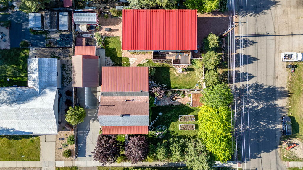 Overhead perspective highlighting the property with its red metal roof and multiple outbuildings