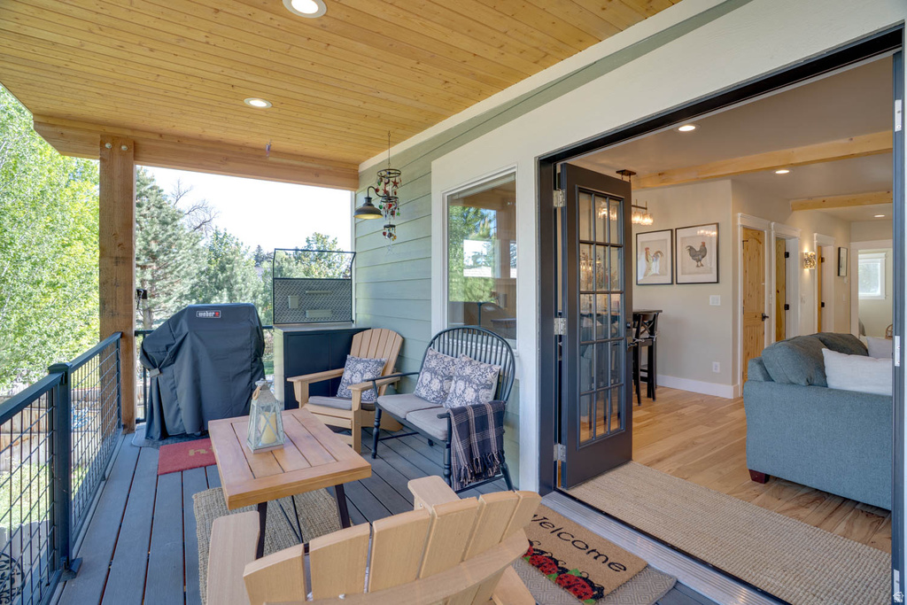 Spacious covered deck featuring a wood-finish ceiling, recessed lighting, and durable composite decking