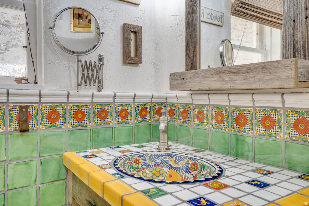 Custom tiled vanity with an integrated basin, featuring a unique hand-painted design