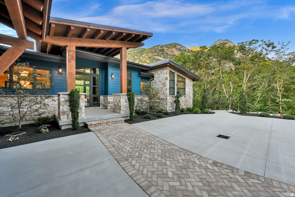 Modern residence featuring an expansive concrete driveway and a herringbone paver walkway