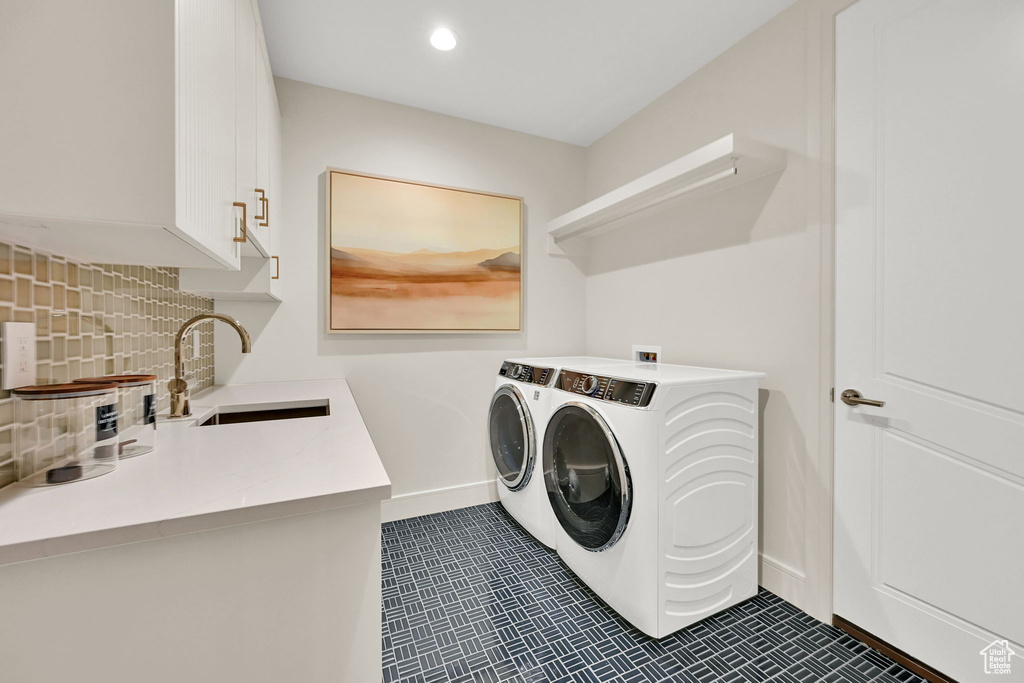 Utility room featuring a built-in sink with a gooseneck faucet, white cabinetry with gold-tone hardware, and a mosaic tile backsplash