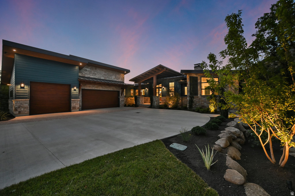 Contemporary exterior featuring mixed material siding, stone accents, and a distinctive angled roofline