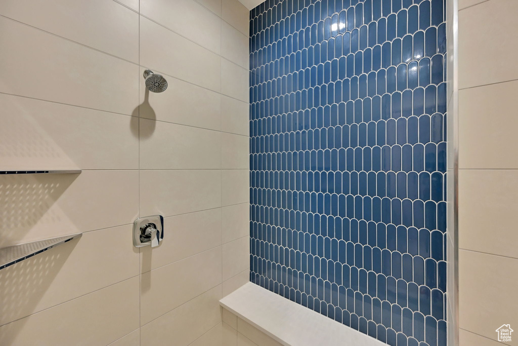 Shower enclosure featuring a blue picket tile accent wall