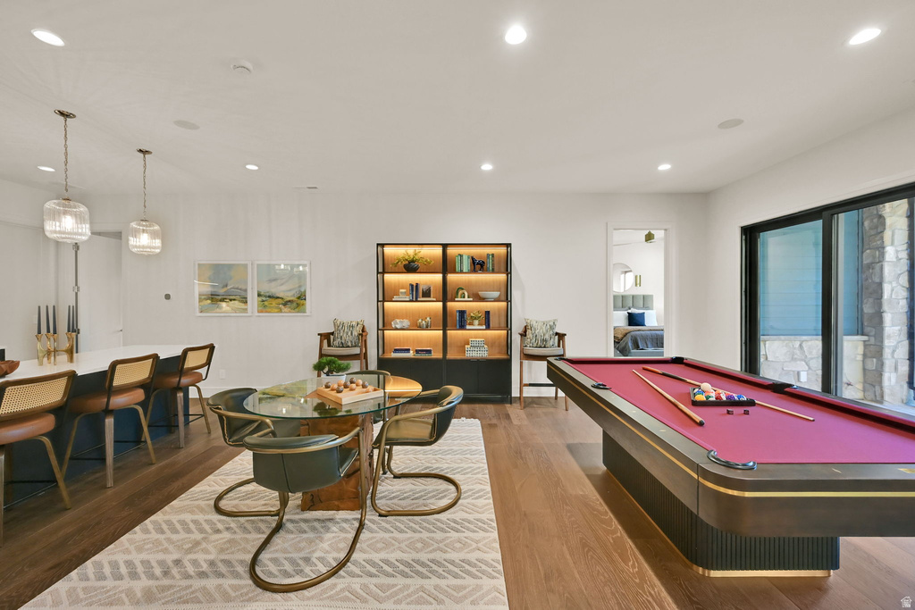 Spacious entertainment area featuring wood-finish flooring, recessed lighting, and a white ceiling