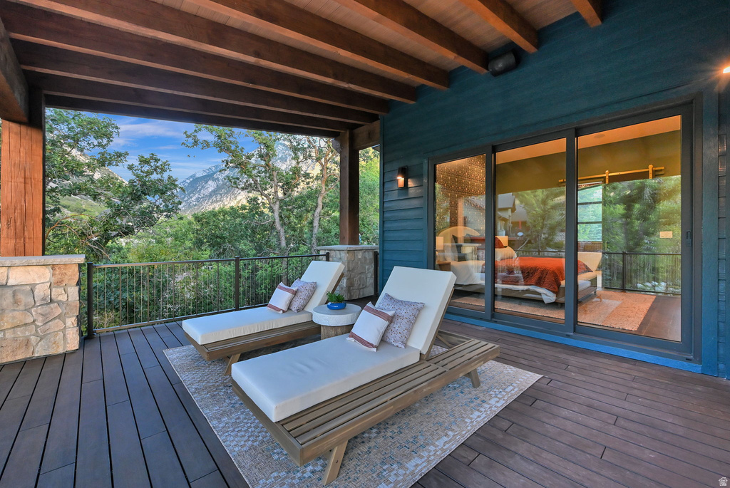 Expansive covered deck featuring composite decking and stone-clad pillars