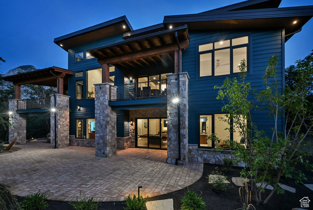 Contemporary multi-story residence featuring blue siding and stone columns