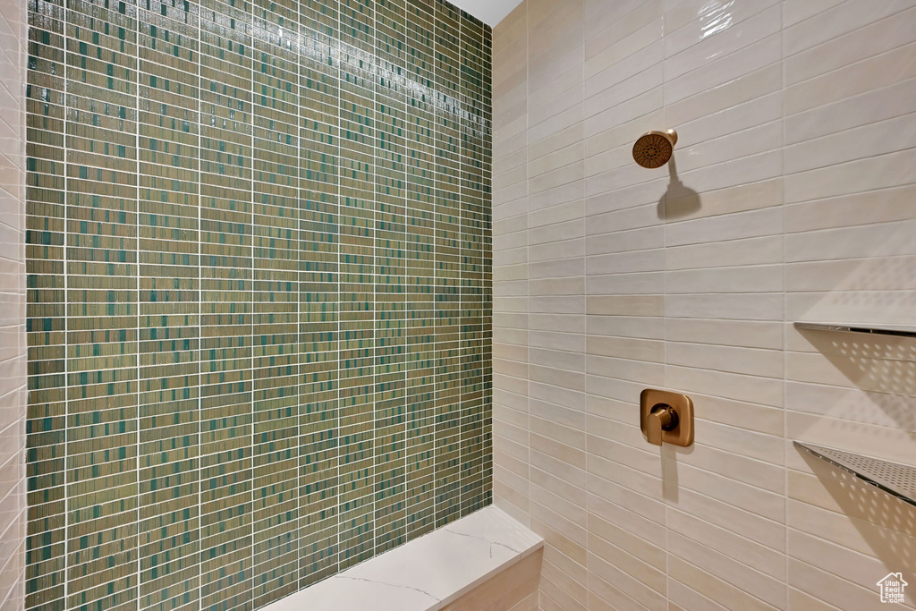 Shower featuring a mosaic tile accent wall, large format rectangular wall tiles, and brushed bronze fixtures