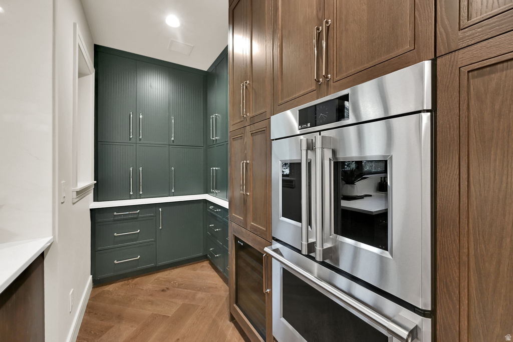 Built-in stainless steel double oven with a paneled wood-finish cabinetry surround