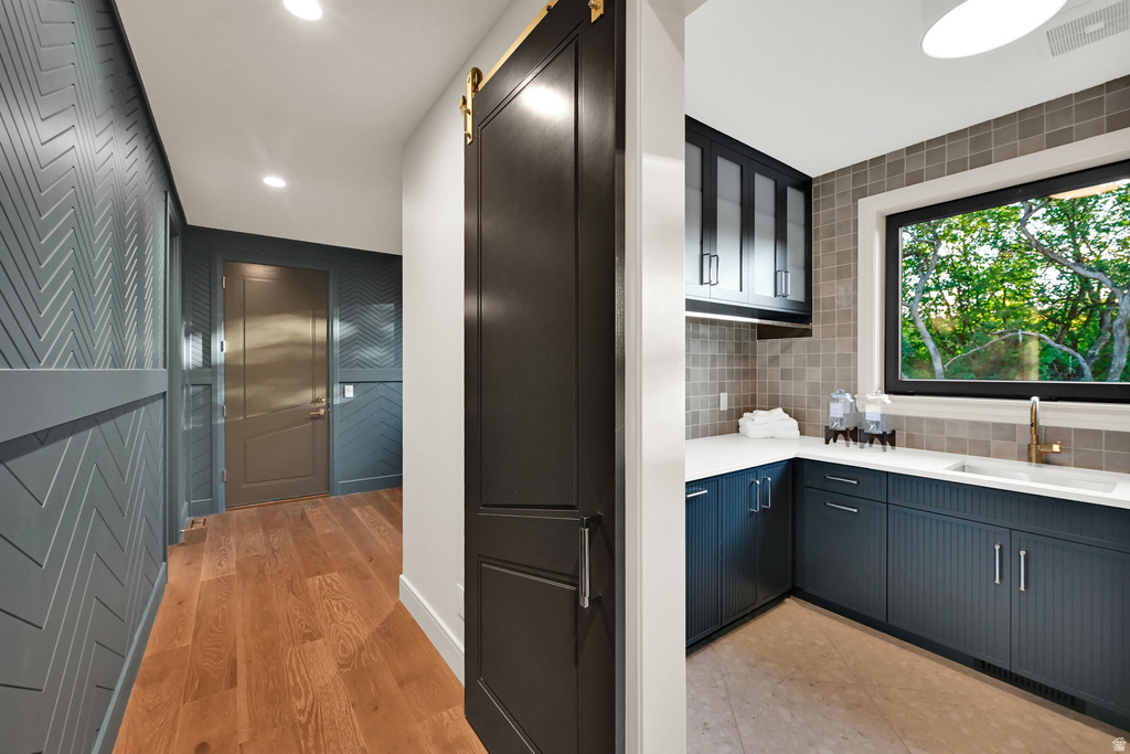 Hallway featuring chevron-patterned wainscoting and warm wood-finish flooring