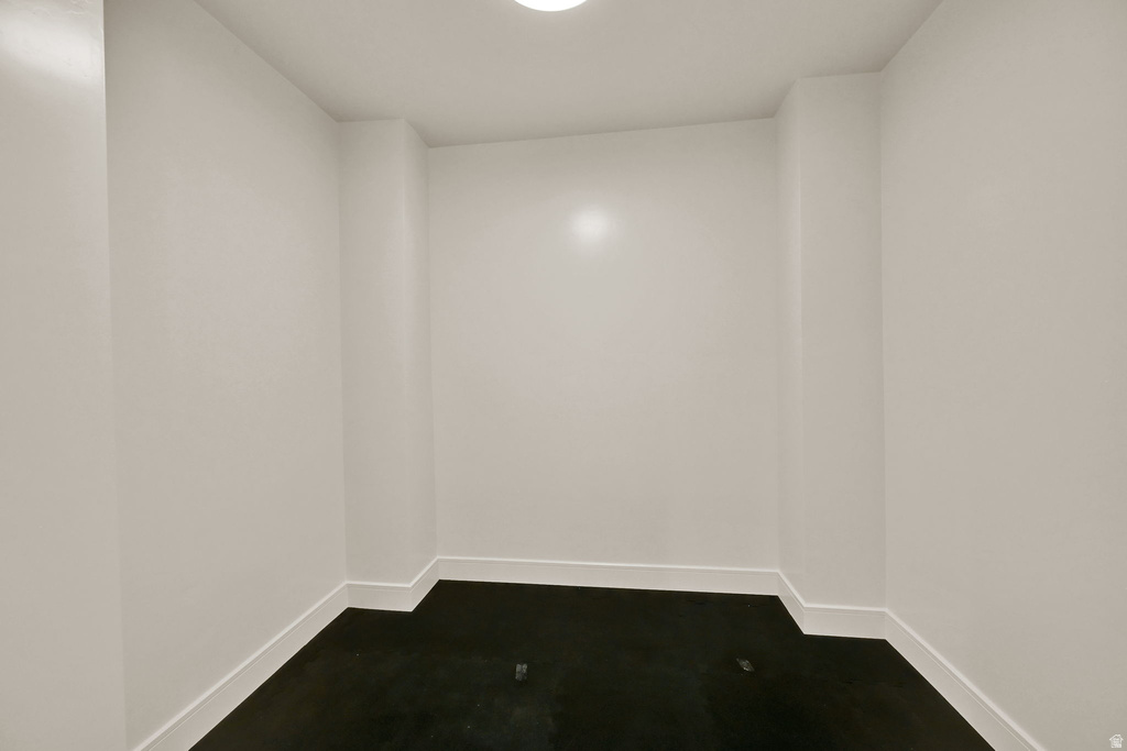 Compact interior space featuring white walls, dark flooring, and a flush-mount ceiling light fixture