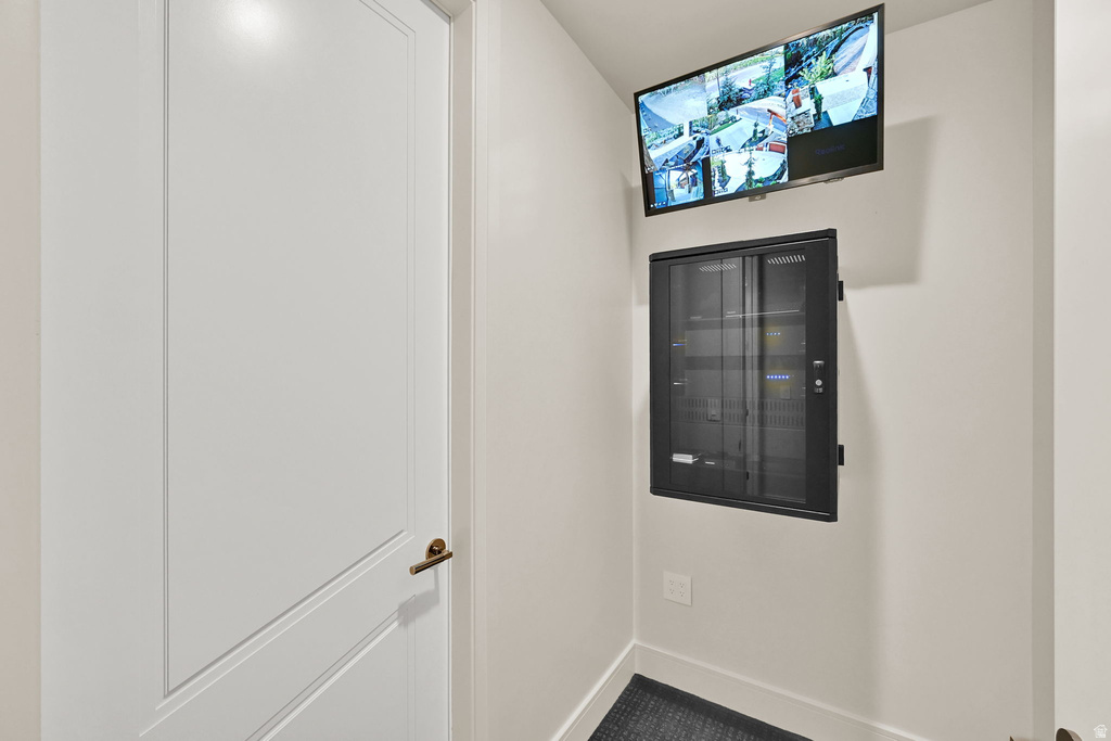 Integrated security monitoring system featuring a wall-mounted display and network cabinet