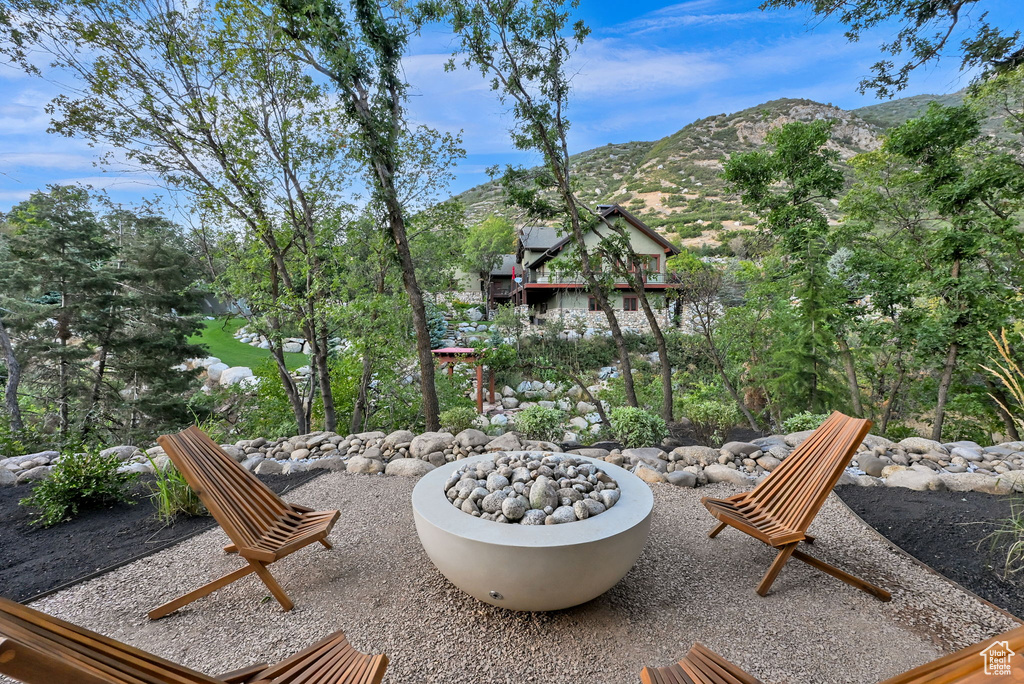Outdoor living space featuring a concrete fire pit, gravel ground cover, and surrounding rock landscaping