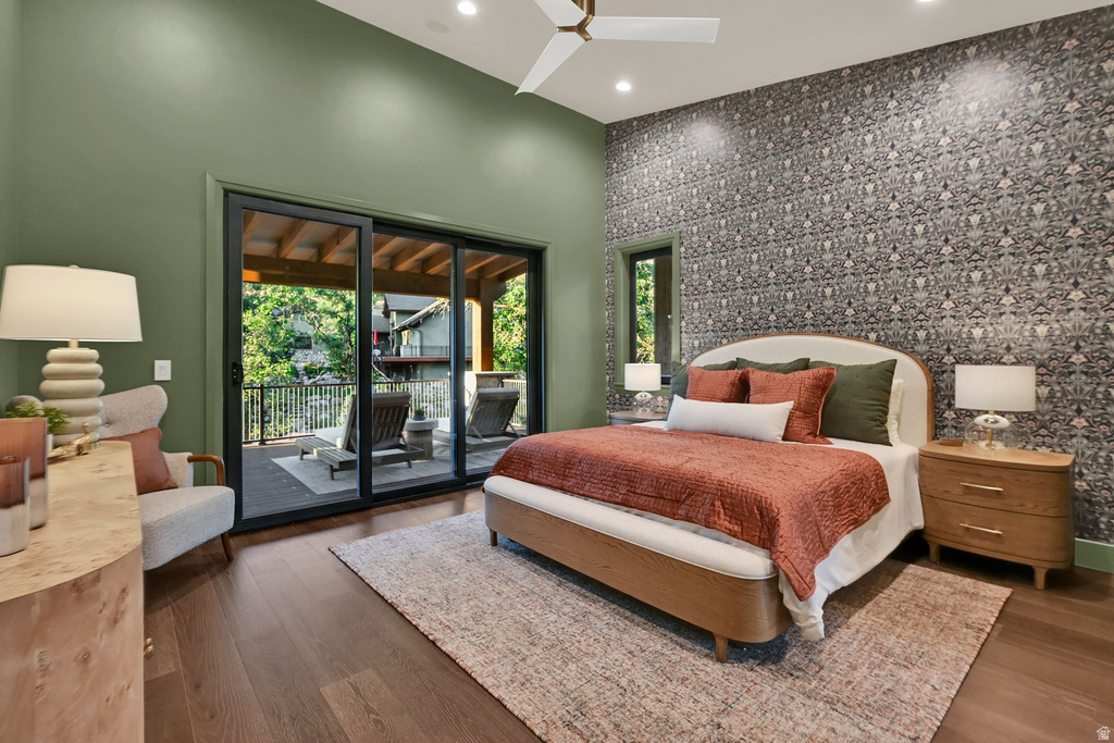 Spacious room featuring wood-finish flooring, a patterned accent wall, and a high ceiling with recessed lighting