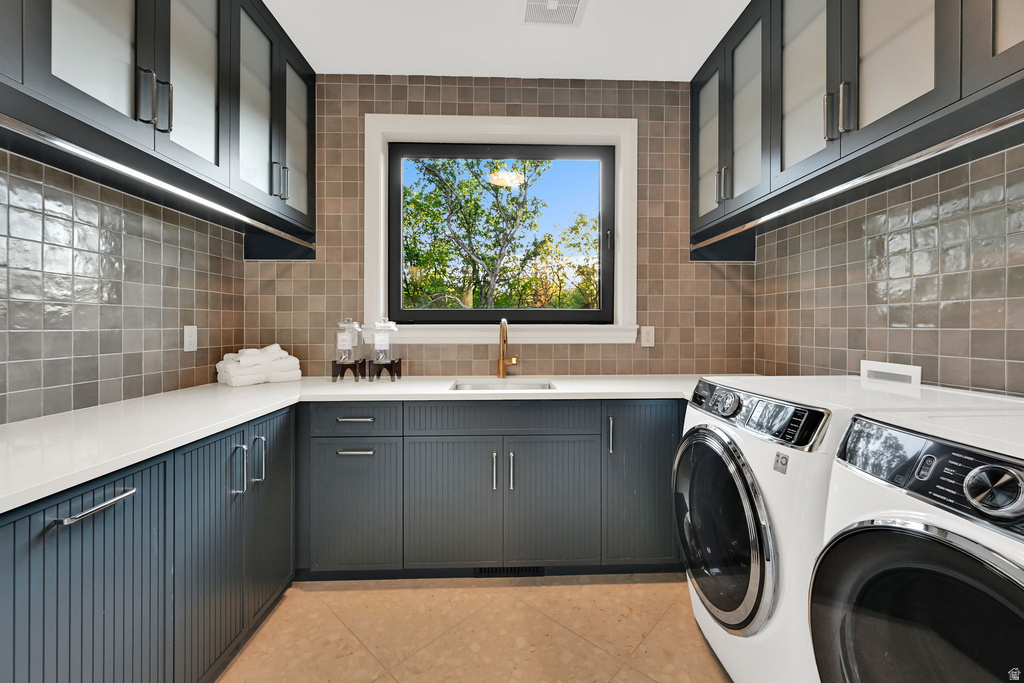 Dedicated utility room featuring ample white countertop space, extensive dark cabinetry with varied paneling, square tiled backsplash, and recessed lighting