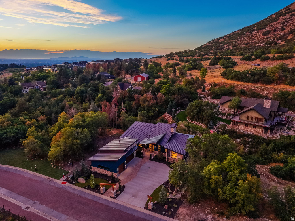 Contemporary residence featuring a metal roof, stone and siding exterior, multi-car garage, and a concrete driveway