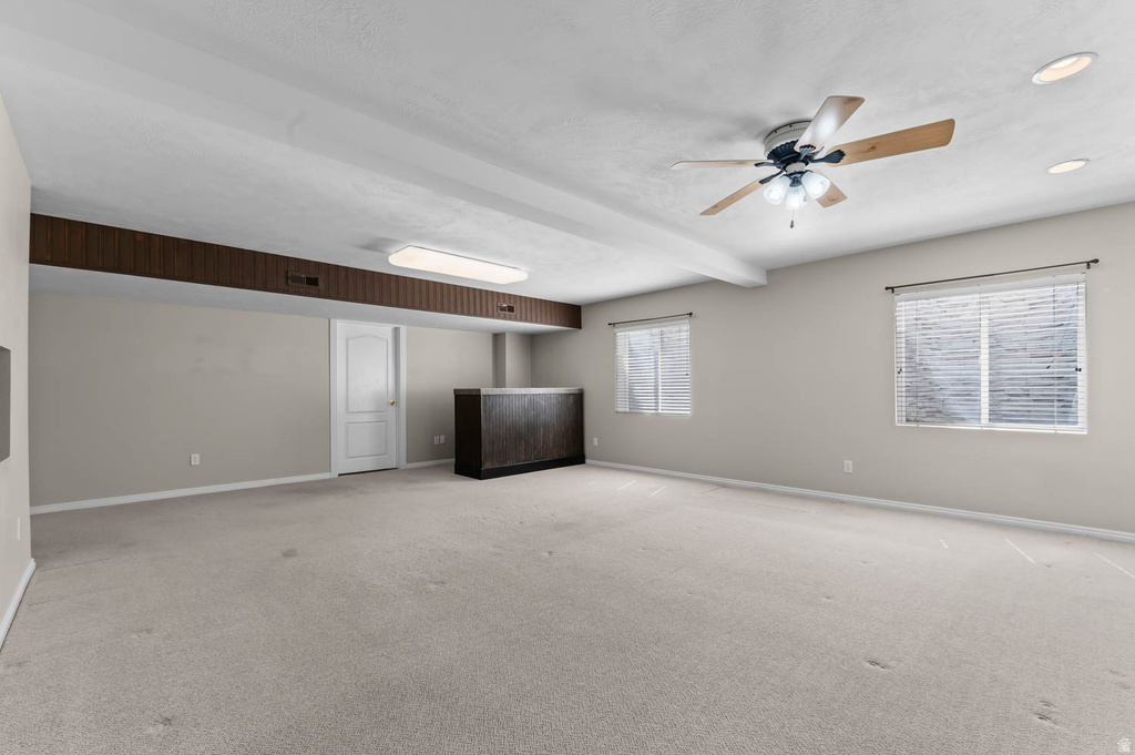 Spacious room featuring light-colored carpeting and neutral wall tones