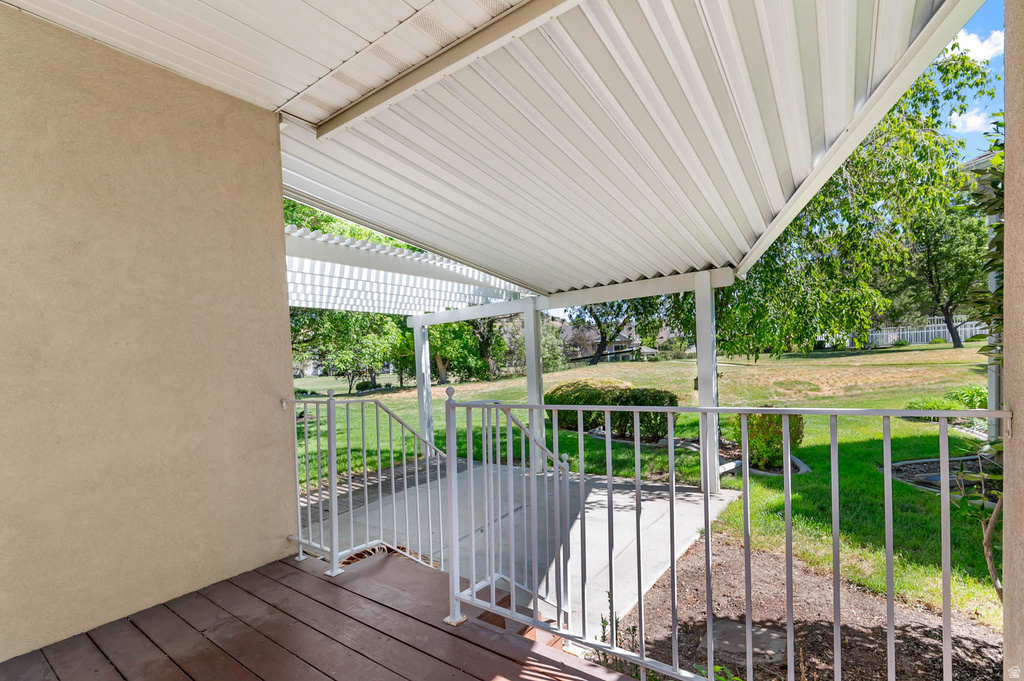 Covered outdoor patio area featuring a slatted ceiling and wood-finish flooring