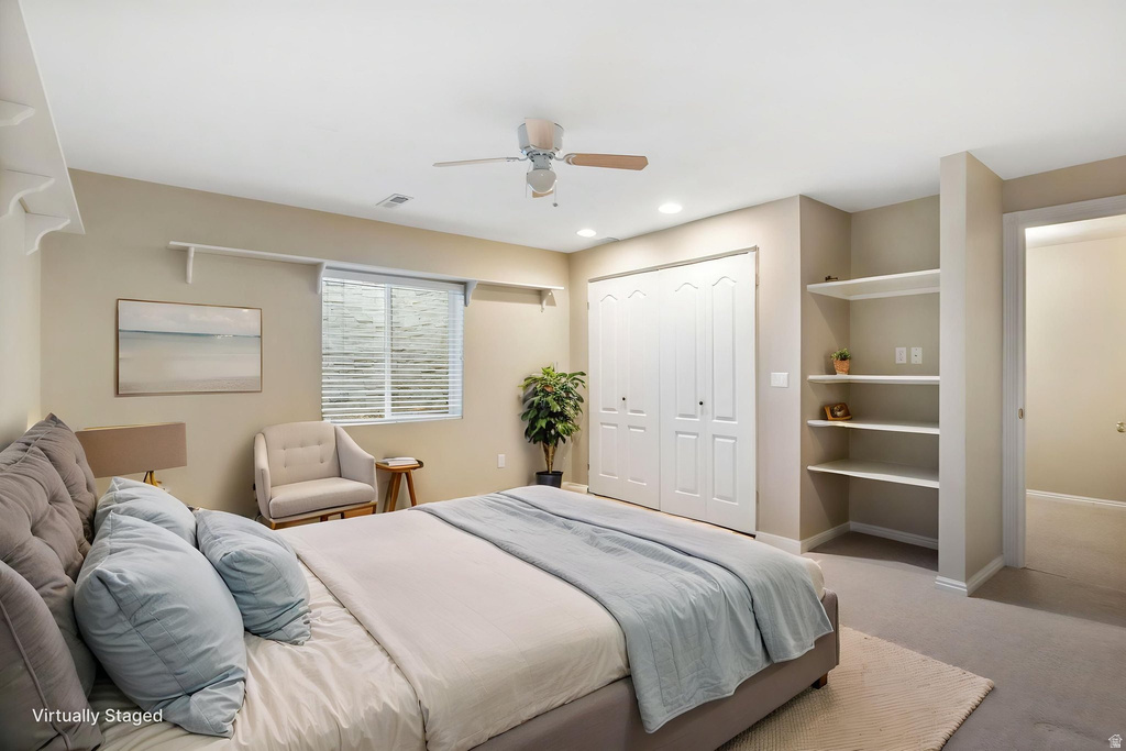 Carpeted interior space featuring a window with blinds, a ceiling fan, recessed lighting, built-in shelving, and bifold closet doors