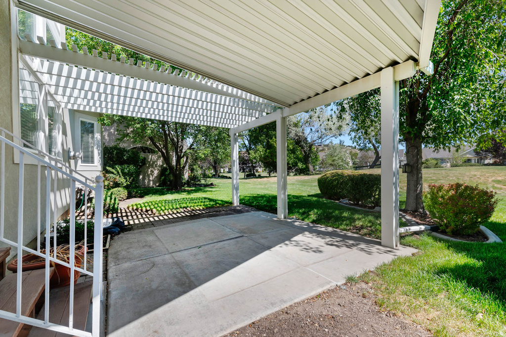 Covered patio with a slatted pergola extension and a concrete surface