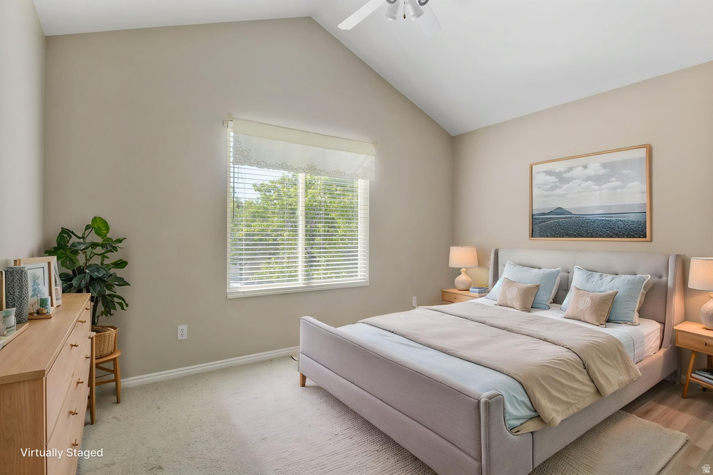 Room featuring a vaulted ceiling, large window with blinds, and neutral wall tones