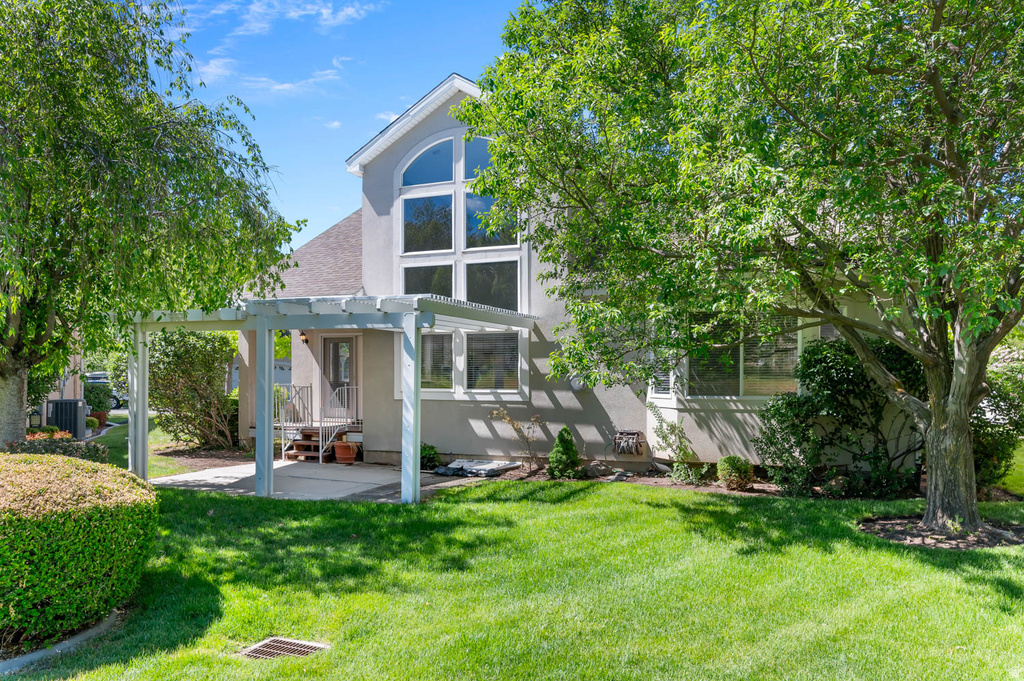 Expansive green lawn with mature trees providing natural shading