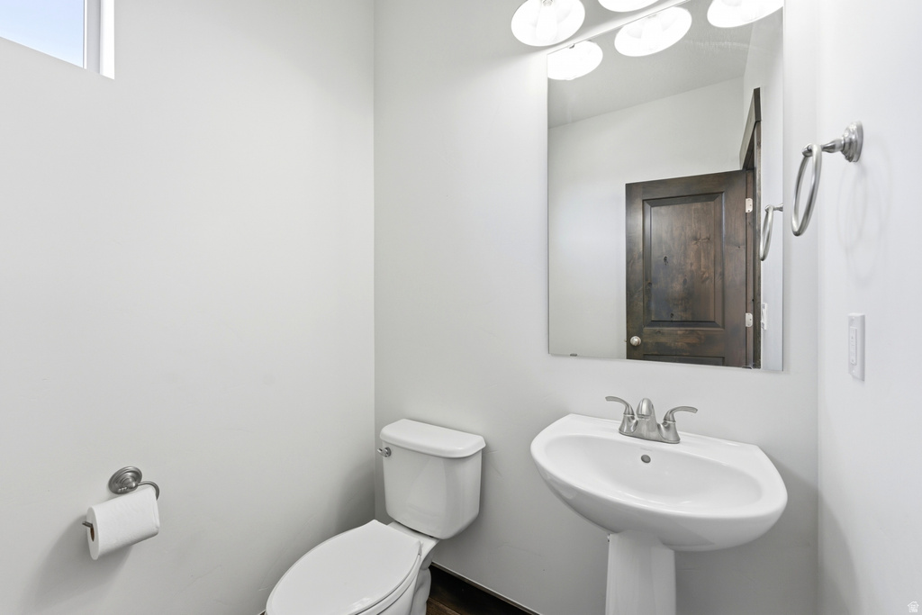 Pedestal sink with chrome-finish faucet and wall-mounted mirror