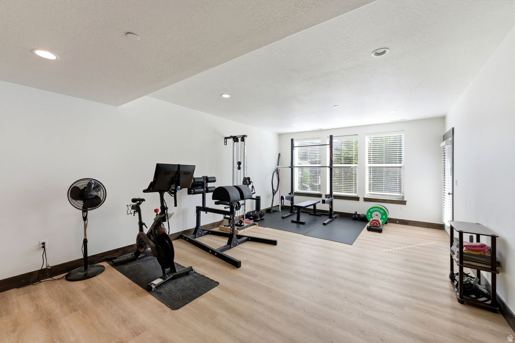Spacious room featuring light wood-finish flooring and recessed lighting