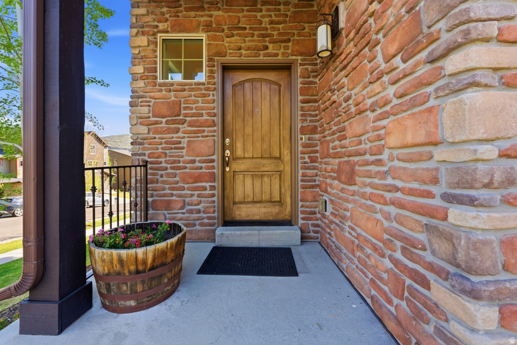 Crafted wood-paneled entry door with sidelight window, set against a multi-toned stone facade