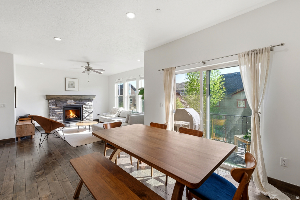 Spacious interior featuring wood-finish flooring, a stone-faced fireplace, recessed lighting, and a ceiling fan