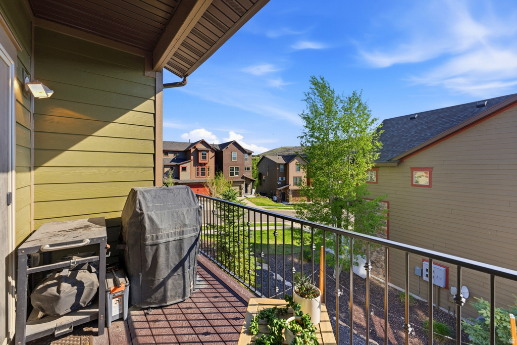 Private balcony featuring composite decking, a black metal railing, and a durable siding exterior