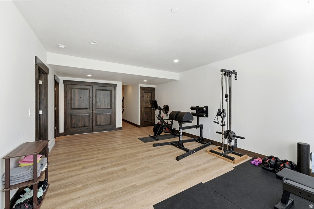 Versatile lower-level space featuring wood-finish flooring, recessed lighting, and dark wood trim
