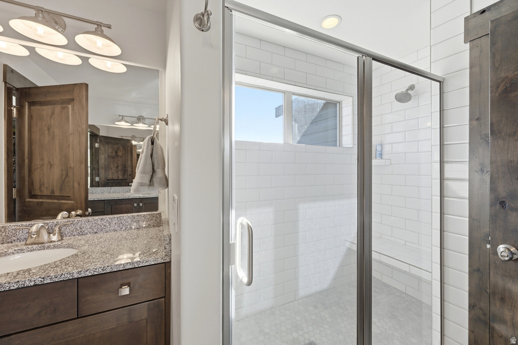 Shower enclosure with white subway tile surround and hexagon tile flooring, featuring a clear glass door