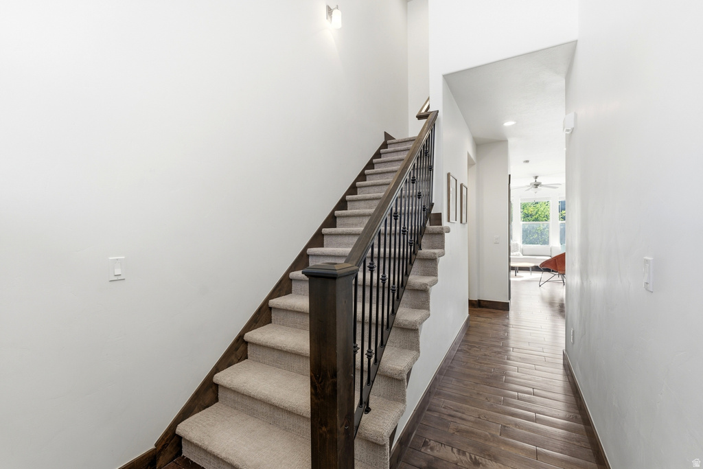 Staircase featuring dark wood newel posts and handrail with decorative black metal balusters, complemented by carpeted treads