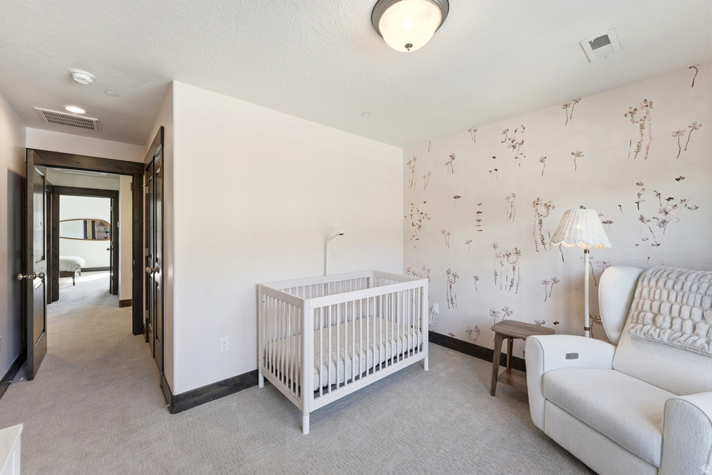 Bedroom featuring a decorative accent wall, recessed lighting, and light-toned carpeting