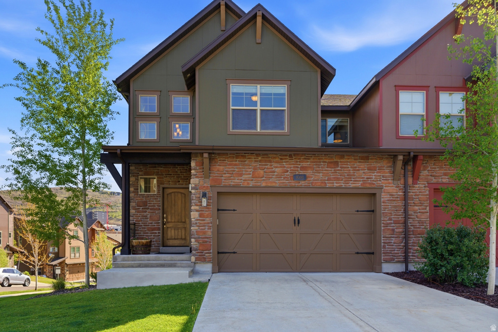 Contemporary facade featuring a prominent two-car garage with a panel door