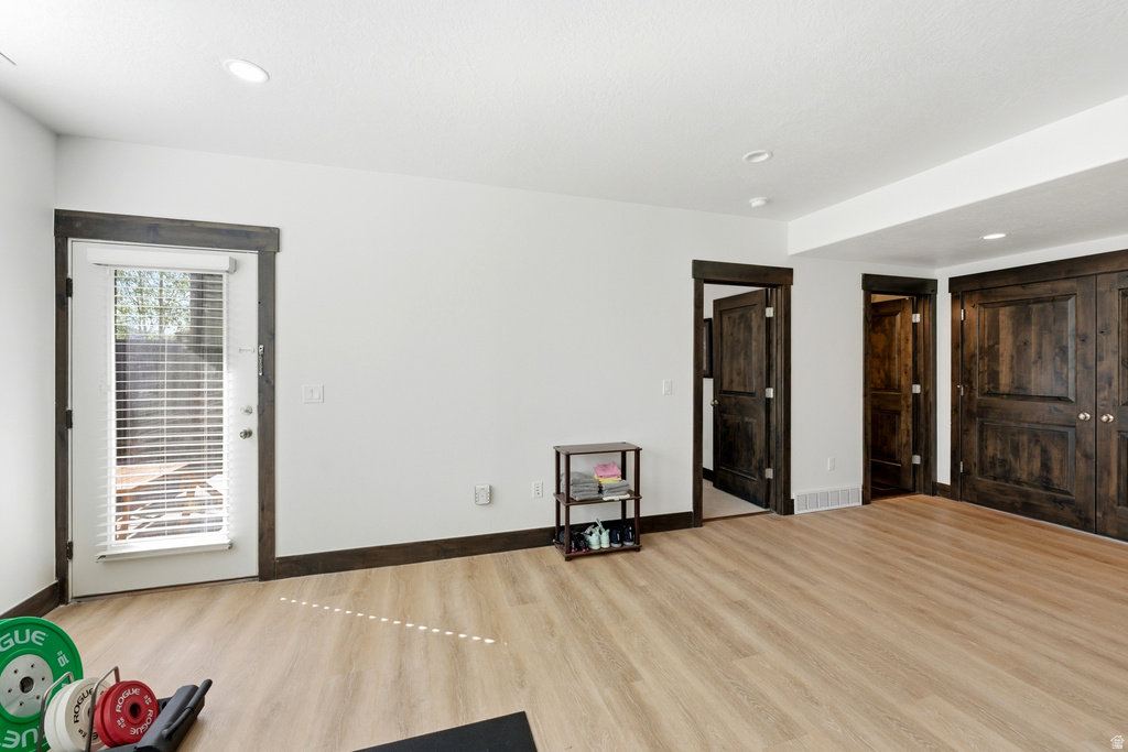 Bright room featuring light wood-finish flooring and recessed lighting