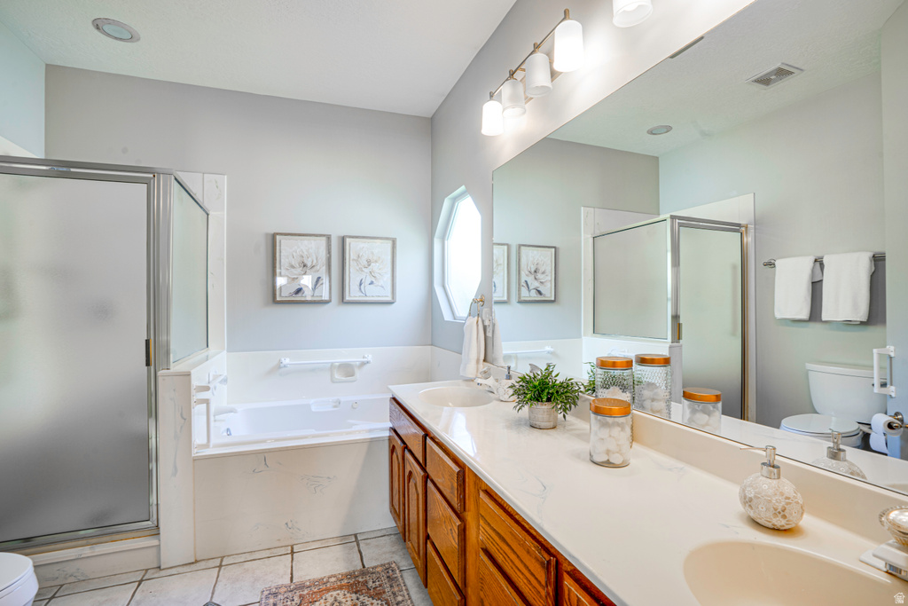 Double vanity with integrated sinks and wood cabinetry, large soaking tub, separate shower with frosted glass enclosure, and a prominent wall-mounted mirror