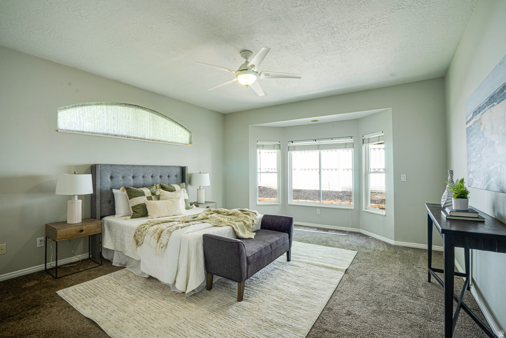 Spacious room featuring a large bay window, arched transom window, and ceiling fan