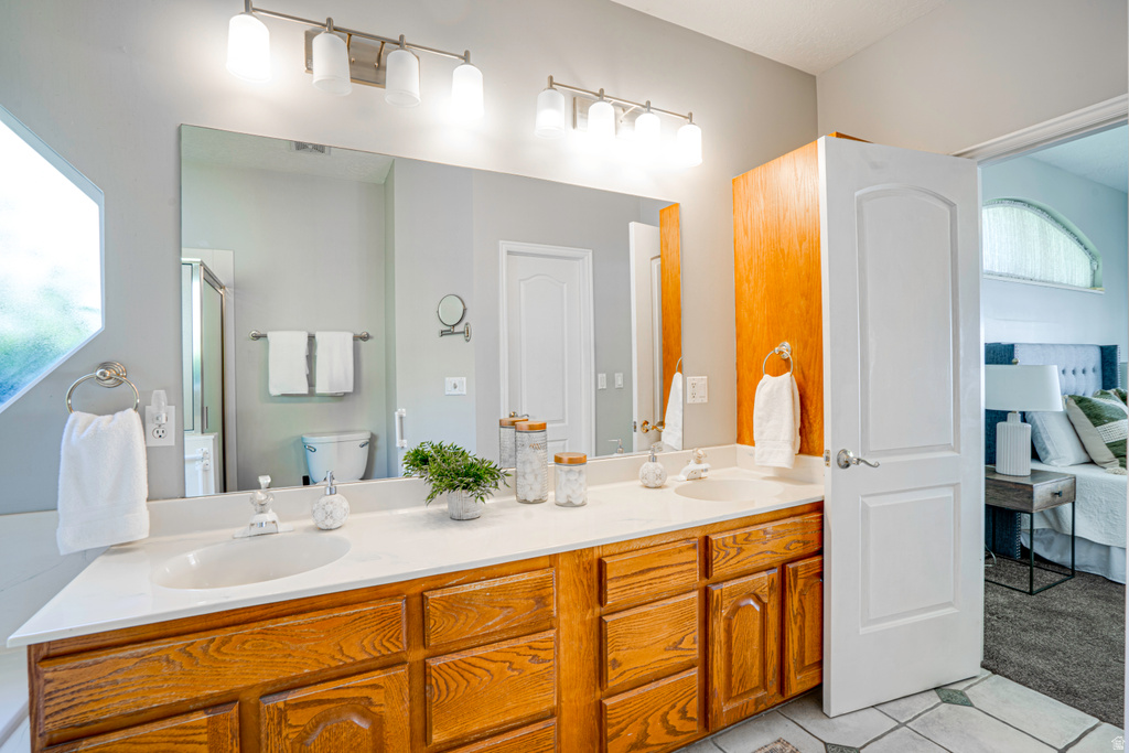 Double vanity with light wood cabinetry and a white countertop