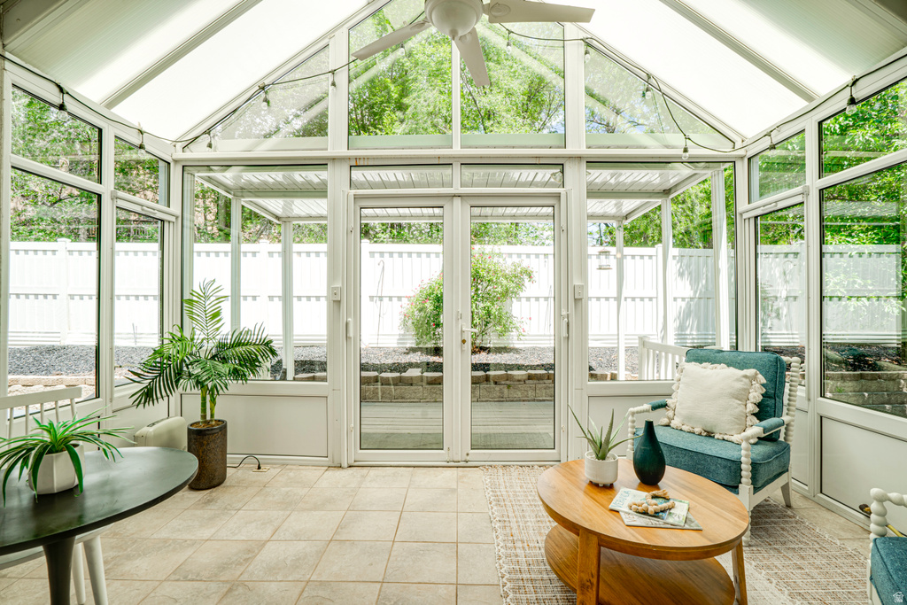 Sunroom featuring a vaulted glass ceiling, full-height windows, tiled flooring, and double glass doors opening to the exterior
