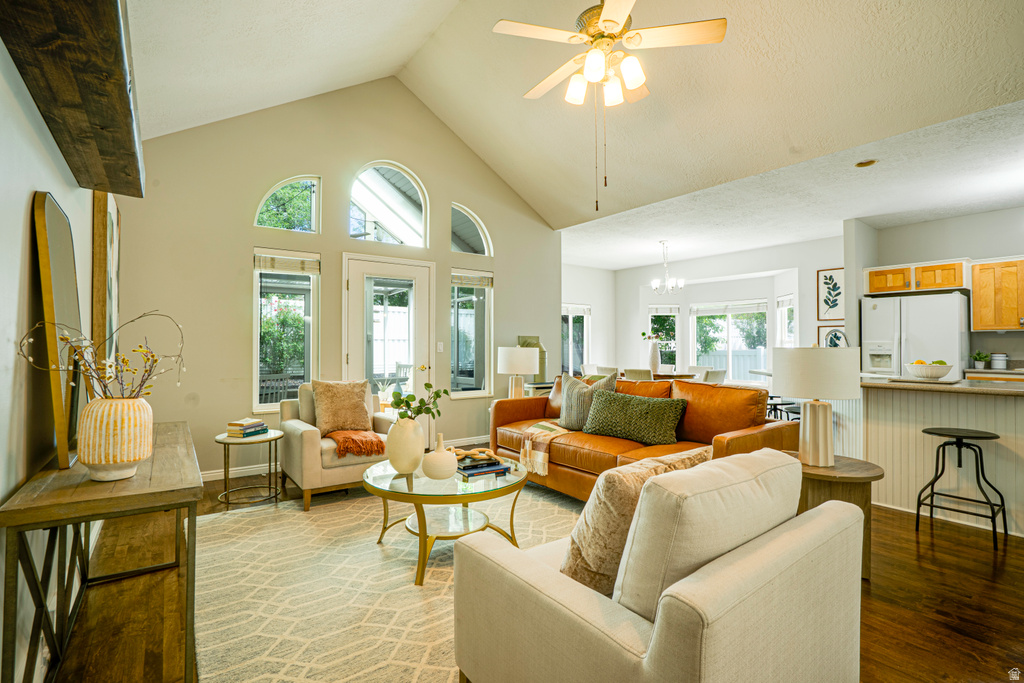 Vaulted ceiling living area featuring multiple arched windows and a glass-paneled door