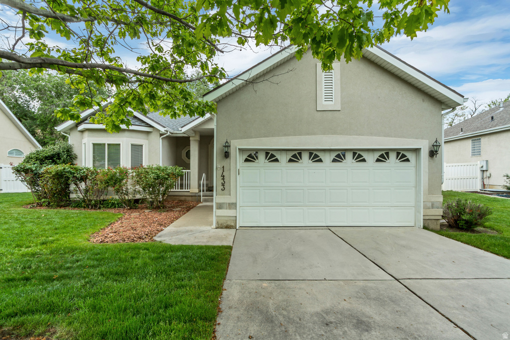 Stucco exterior with a two-car garage featuring decorative transom windows and a concrete driveway