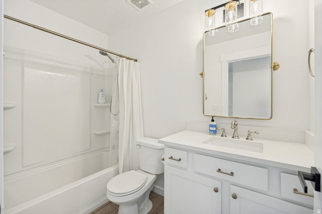 White bathroom vanity with a light-toned countertop, brushed nickel faucet, and a large framed mirror