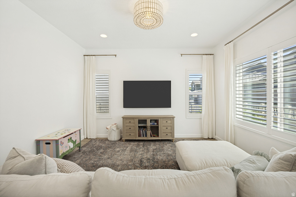 Bright living area featuring white walls, recessed lighting, and a decorative ceiling fixture