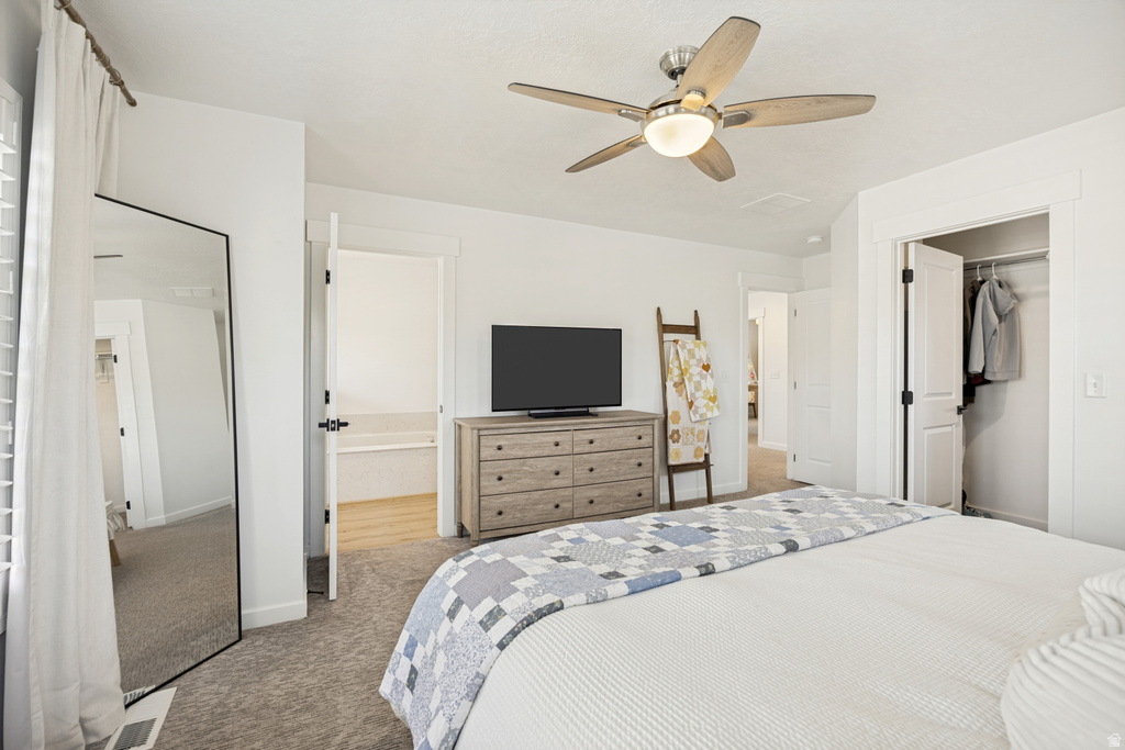 Carpeted bedroom with a ceiling fan, white walls, and a visible closet with bi-fold doors