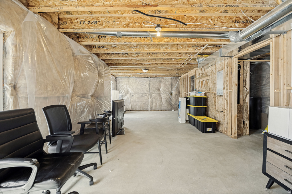 Unfinished basement with exposed ceiling joists and concrete flooring