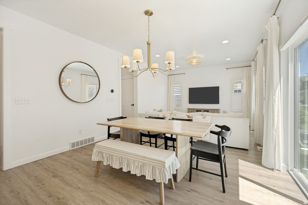 Open-concept living area featuring light wood-finish flooring and white walls
